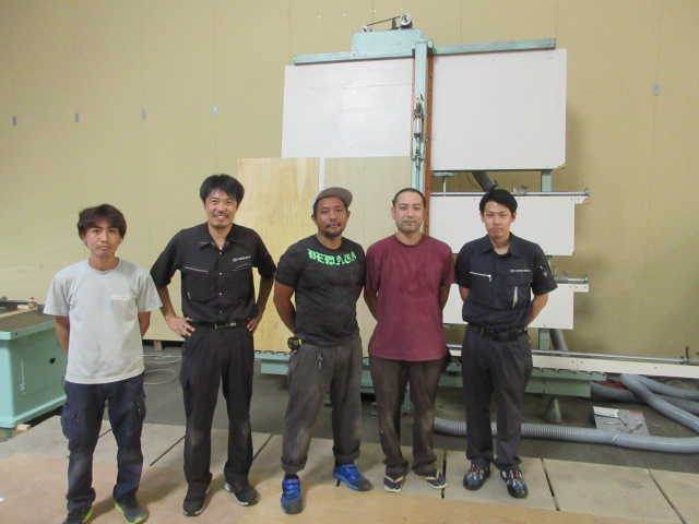 岡川圭吾さん（右から２番目）と同業の皆さまと今回購入頂いた田中機械パネルソーの前で